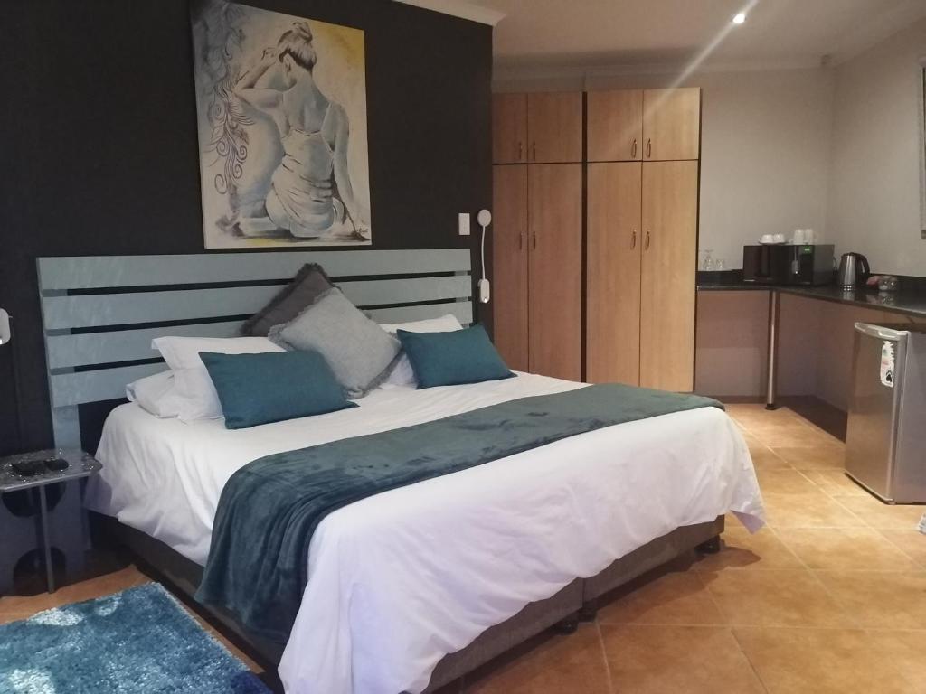 东伦敦Cowrie Lodge at Cove Rock Country Estate的卧室配有带蓝色枕头的大型白色床