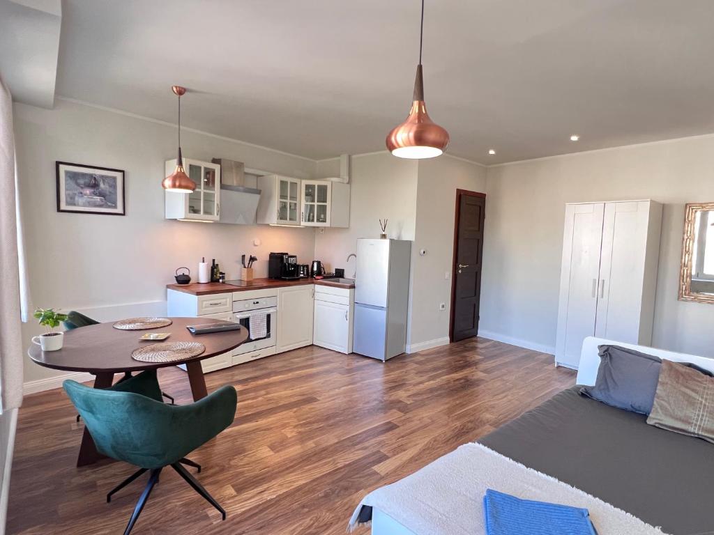 塔林CityView Apartment的厨房以及带桌子和沙发的客厅。