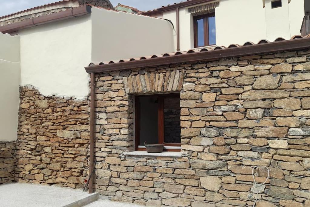 ArmungiaCasa tipica nel borgo antico的一面有窗户的石头建筑