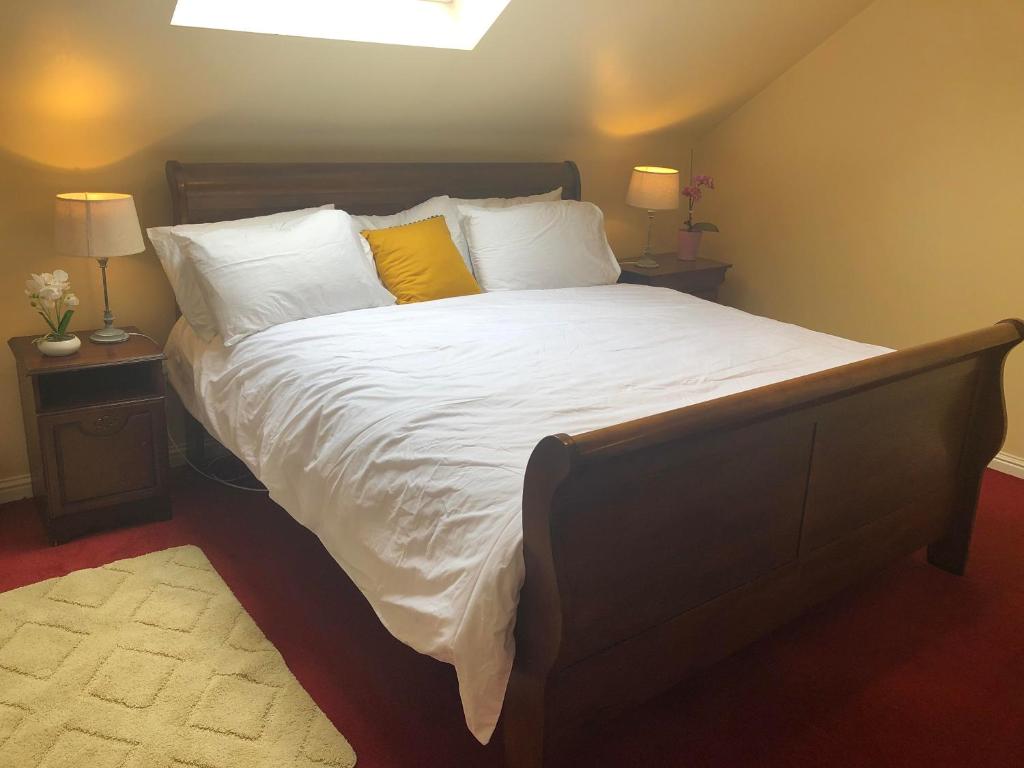克利夫登Railway Avenue Rooms的一间卧室配有一张带白色床单和黄色枕头的大床。