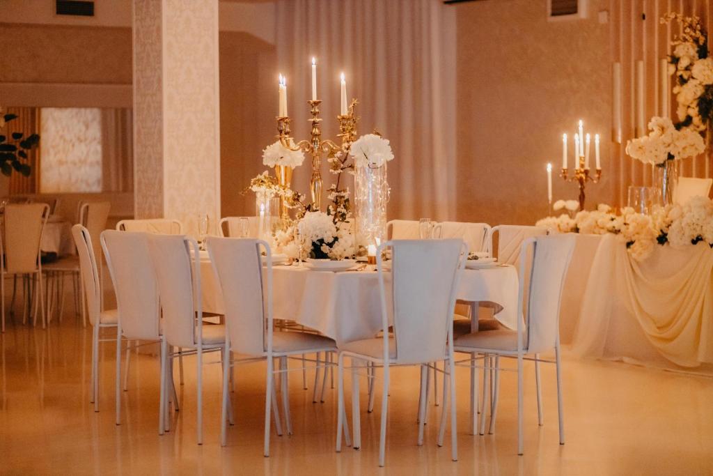 NevesinjeSvadbeni salon i prenoćište MILANOVIĆ的一间配备有白色桌椅和吊灯的餐厅