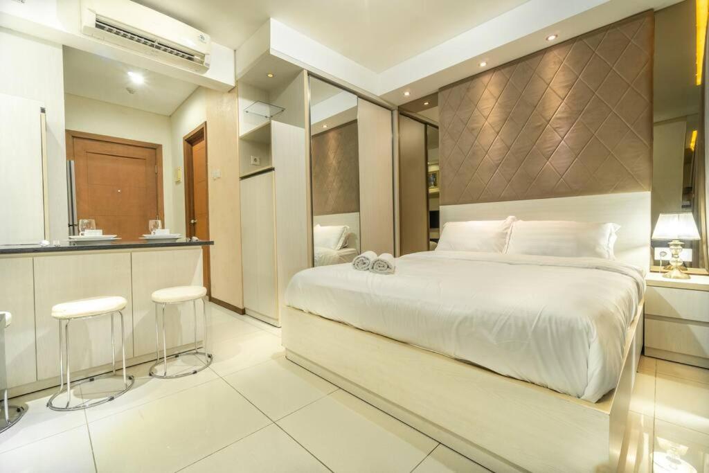 雅加达Modern & comfy studio in central Jakarta, SCBD的一间带白色大床的卧室和一间厨房