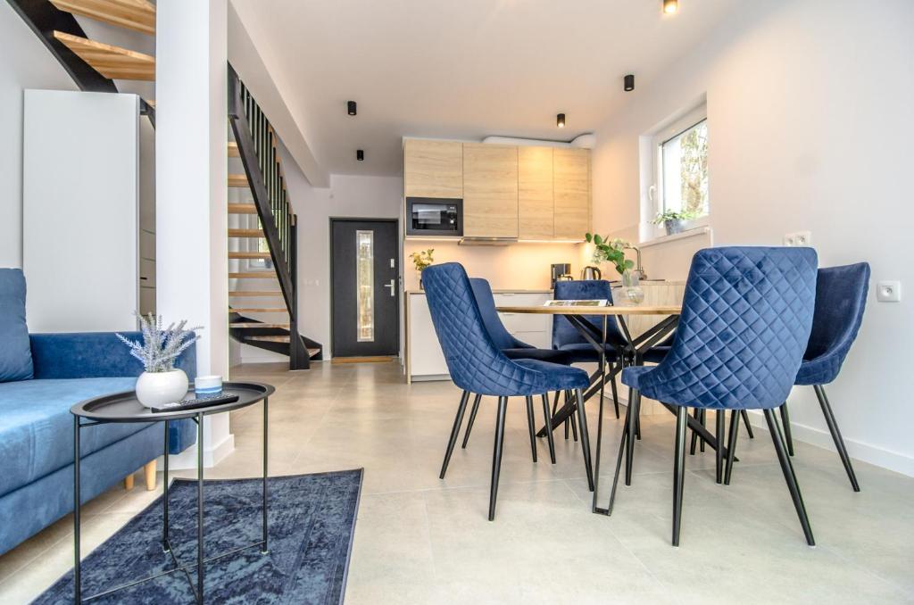 梅尔诺Domki - Villa Buena Vista - Mielno的厨房以及带蓝色椅子和桌子的客厅。