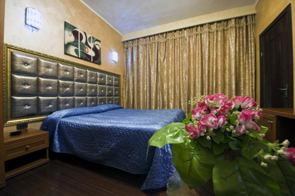 蒙卡列里班加西酒店的一间卧室配有蓝色的床和鲜花