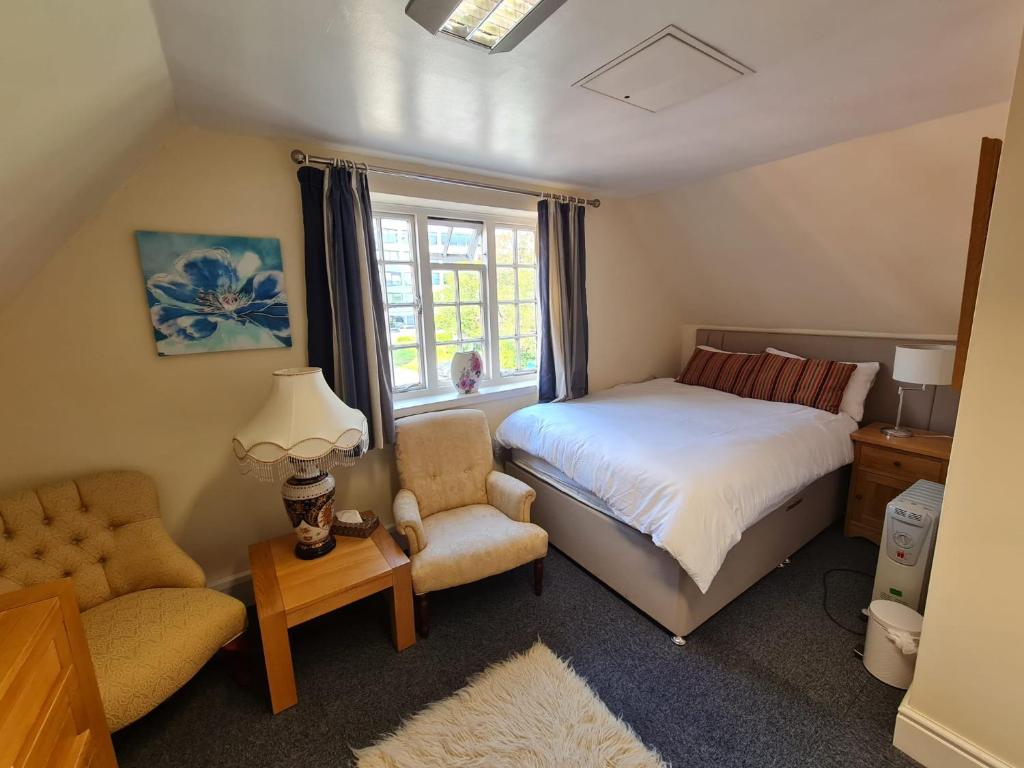 索利赫尔Flat in Solihull town centre, 2 Big rooms的一间卧室配有一张床、一张沙发和一把椅子