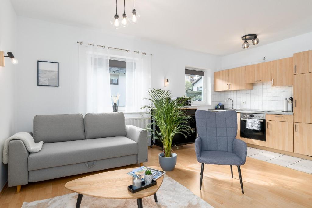 埃德湖Harmony: Edersee Apartment – Sperrmauer – Lounge的客厅配有沙发和桌子