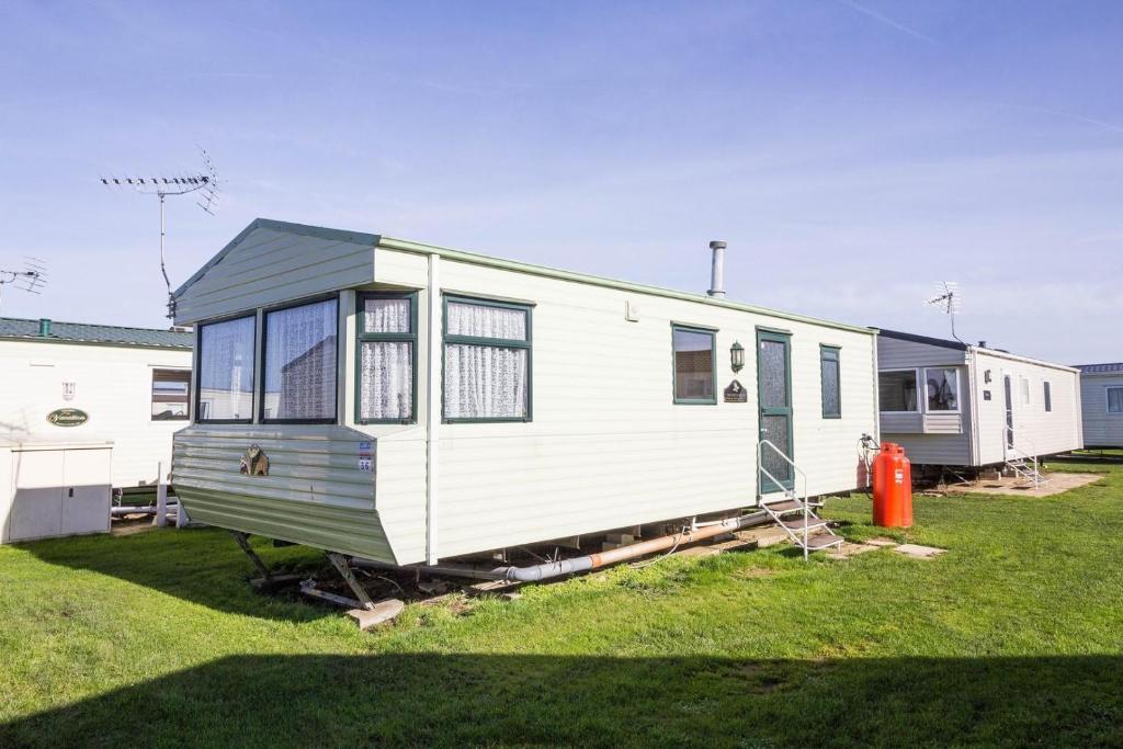 赫彻姆6 Berth Caravan For Hire, Minutes From A Stunning Beach In Norfolk! Ref 21036f的停在草地上的白色拖车