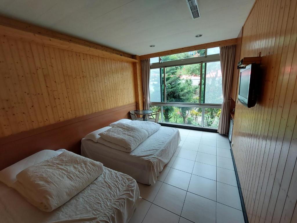 平溪十分幸福民宿的带大窗户的客房内的两张床