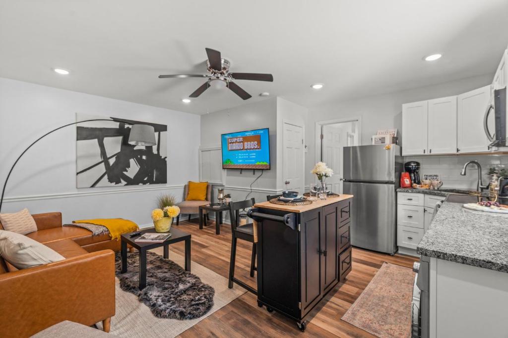 费城East Passyunk Trendy Apartment的厨房以及带沙发和桌子的客厅。