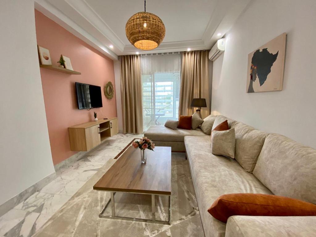 莫纳斯提尔Appart calme & chaleureux en résidence près de la mer的客厅配有沙发和桌子