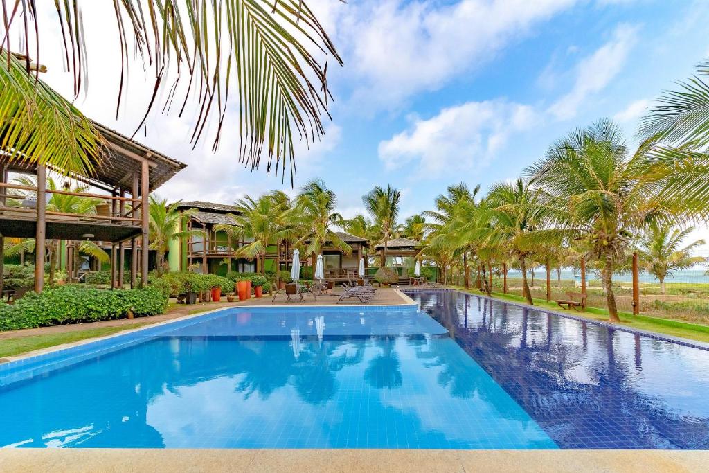 伊塔齐米林IT70 Ótimo Bangalô Duplex Beira Mar的棕榈树度假村前的游泳池