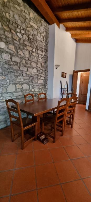 列尔纳La Casetta di Sornico的一张带椅子的木桌和石墙
