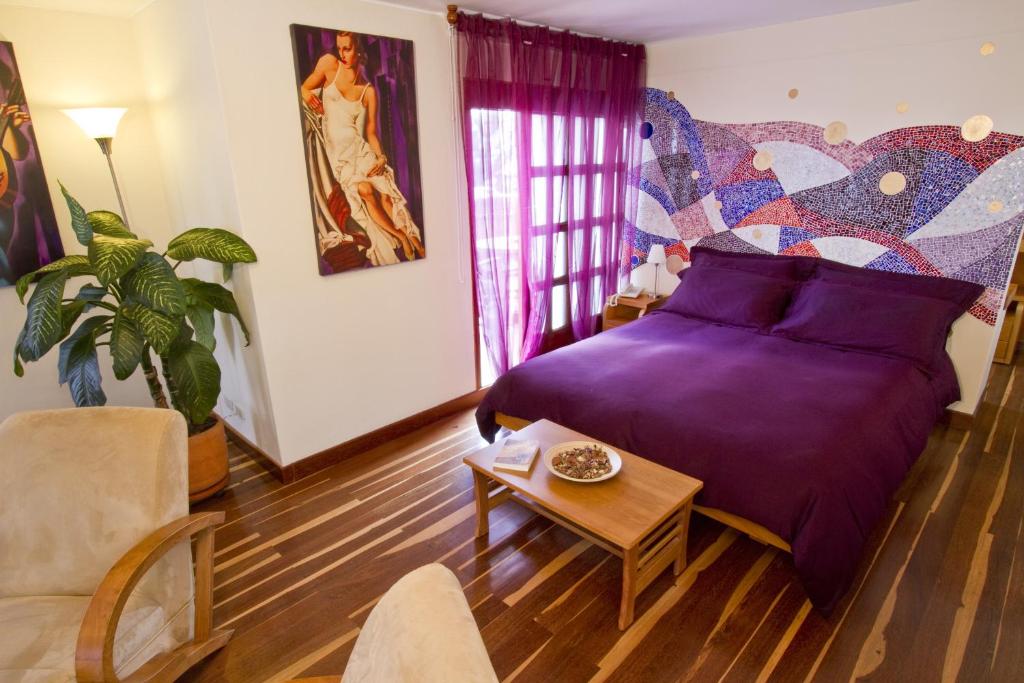 波哥大德卡之家酒店的一间卧室配有一张紫色的床和一张桌子
