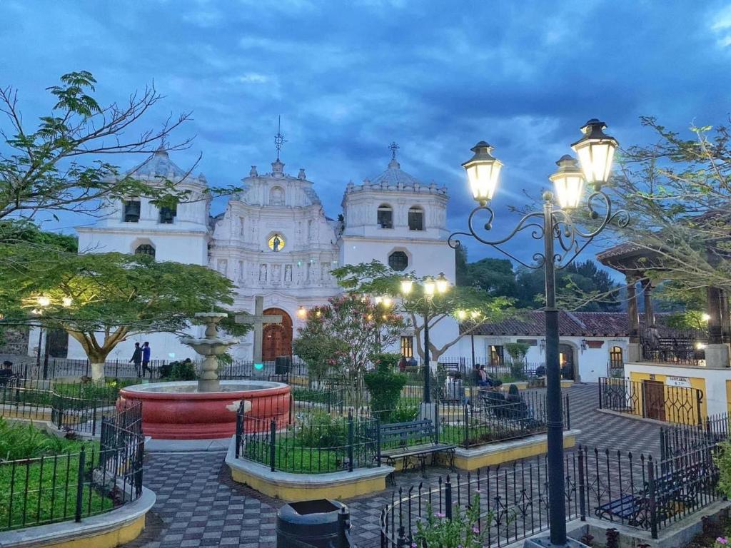 危地马拉Ciudad Vieja Bed & Breakfast Hotel的一座白色的大教堂,前面有一个喷泉