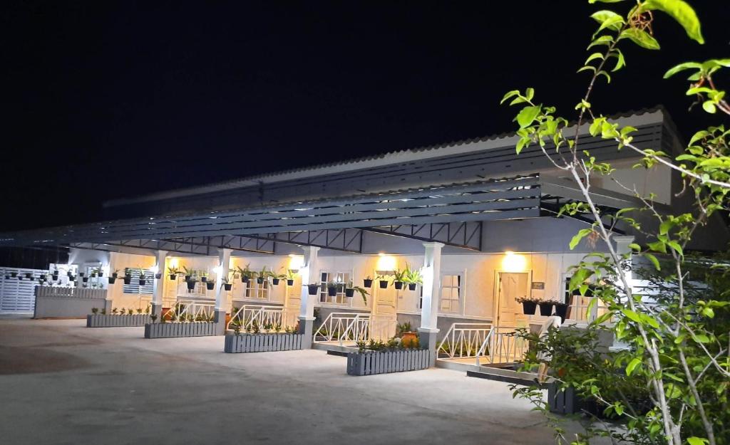 华欣Fancy Carp Resort Hua-Hin的一座灯光建筑,晚上有一排座位