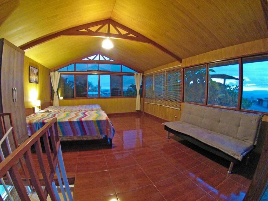 塔拉波托Casita Grau 2! Naturaleza y confort con Agua caliente,cocina y frigobar的一间卧室配有一张床、一张沙发和窗户。