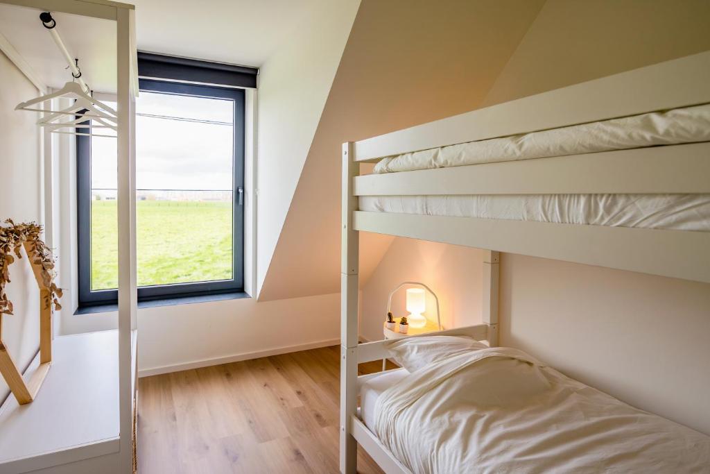 LauweHet Preshoekhuis的一间卧室设有两张双层床和一扇窗户。
