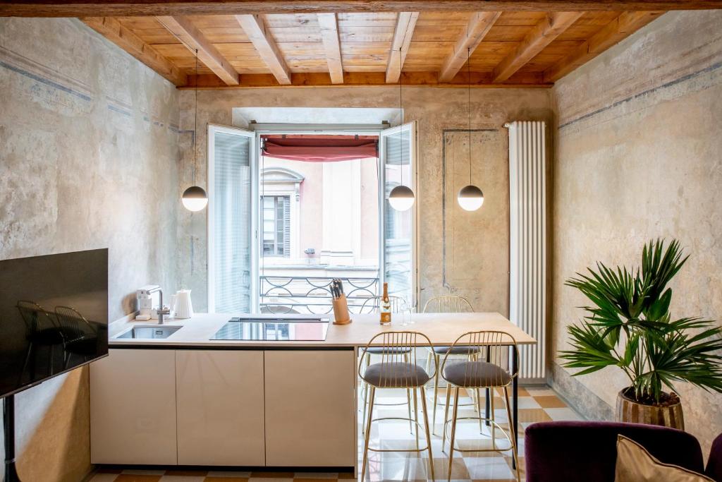 博洛尼亚Palazzo Scappi Gardi Luxury Apartments的一间厨房,内设一个柜台和凳子