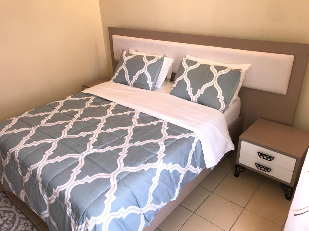 内罗毕Maliaways Comfy Airbnb-Jkia的一张带蓝色和白色床单及枕头的床