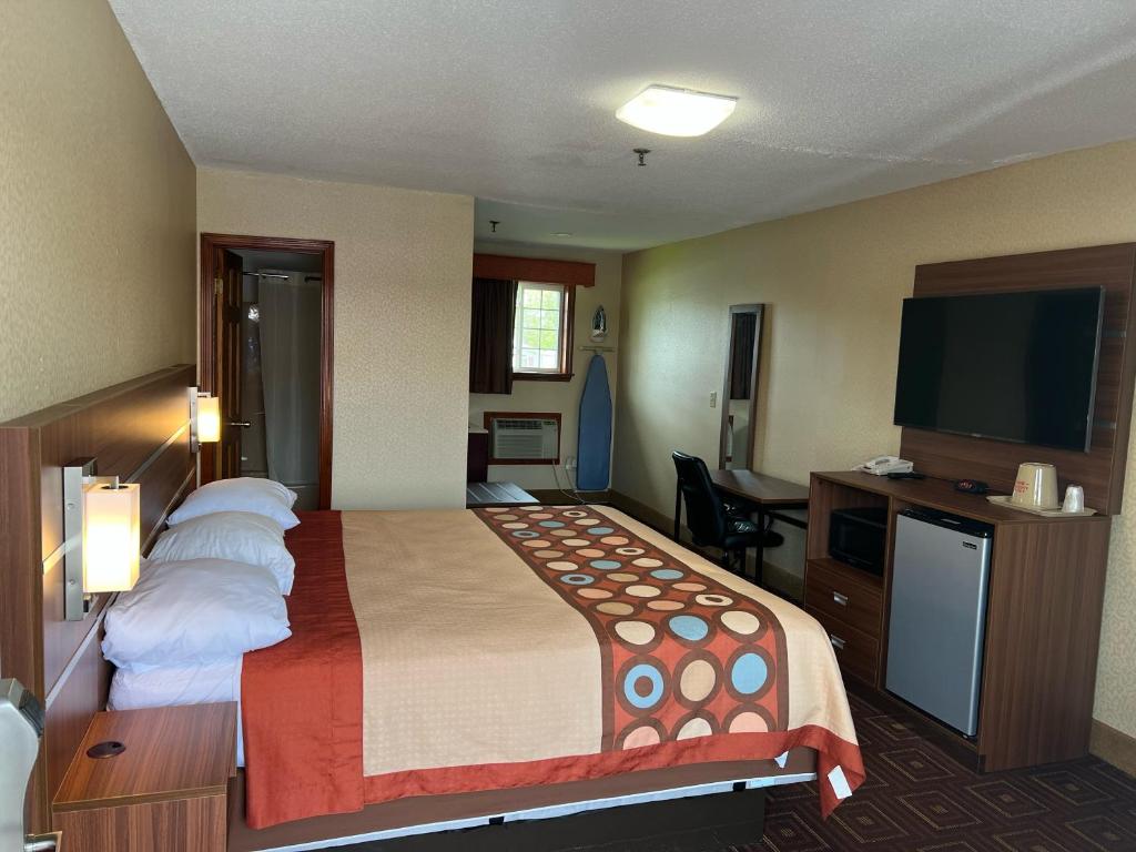 布兰福德American Inn的配有一张床和一台平面电视的酒店客房