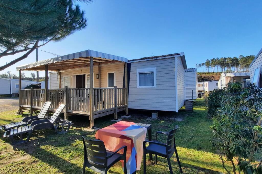 波讷地区圣朱利安Mobil-home Loic camping les Dunes de Contis的一个小房子,配有桌子和椅子