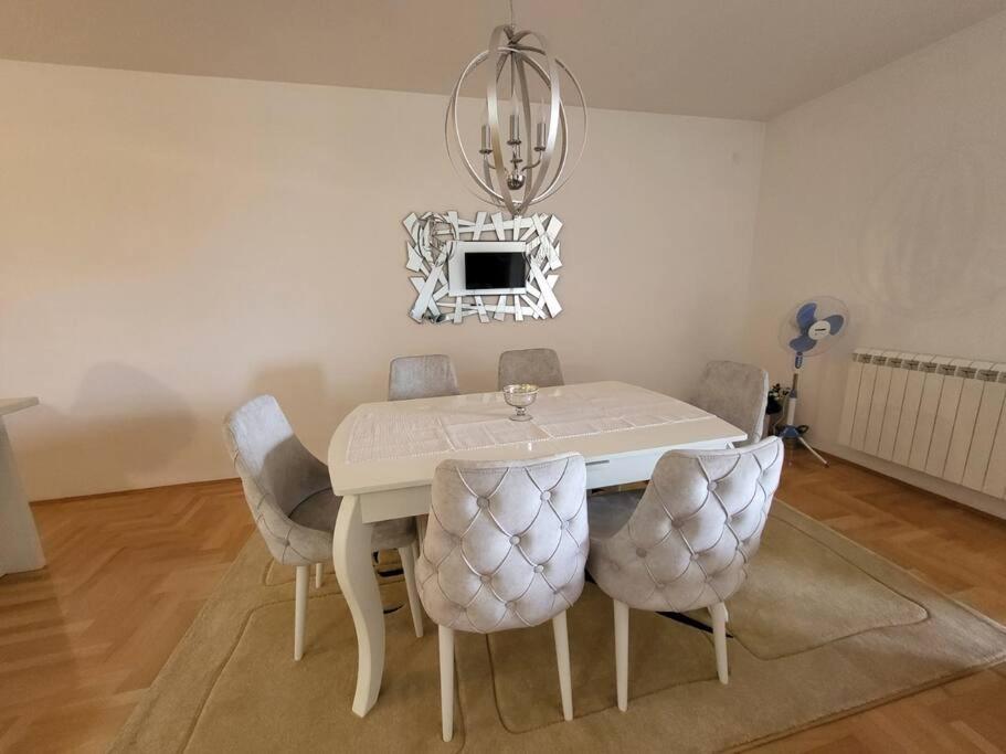 斯特鲁米察Luxury Central Apartment的白色的餐桌、椅子和吊灯