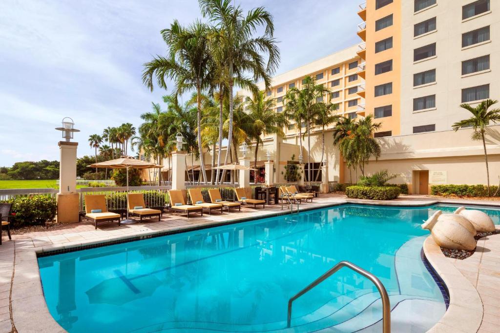 普兰塔寻Renaissance Fort Lauderdale West Hotel的一座带椅子的酒店游泳池,一座建筑