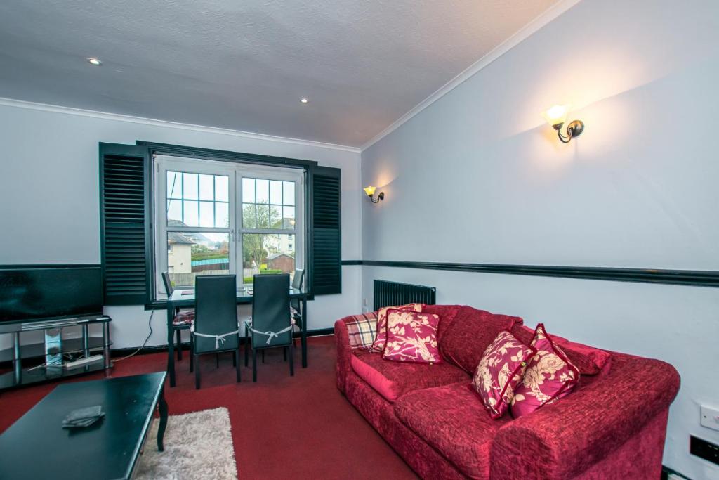 米尔盖Cosy & Central 2BD Apartment Milngavie, Glasgow的客厅配有红色的沙发和桌子