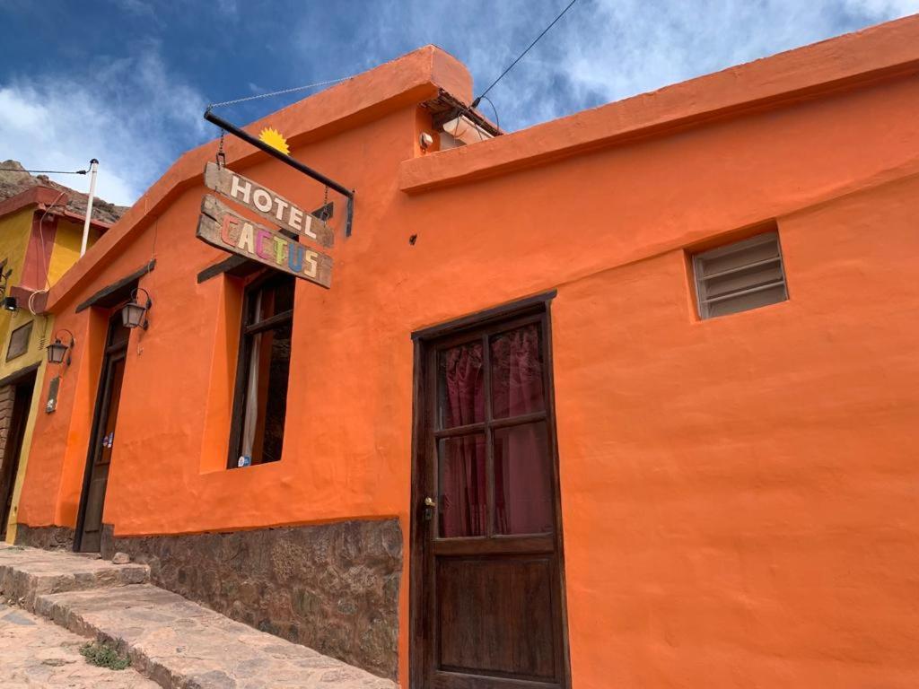 普尔马马尔卡Hotel Cactus Cerro的一座橙色的建筑,在门上方有标志