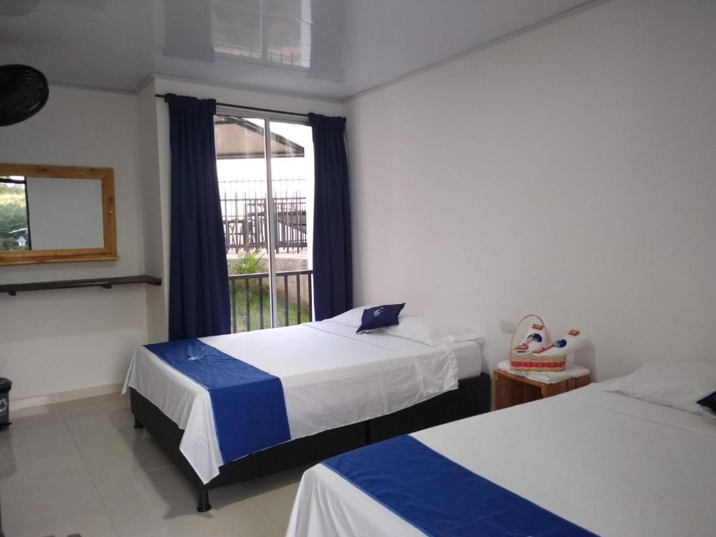 比利亚维哈Cosmos Tatacoa Hotel的酒店客房设有两张床和窗户。