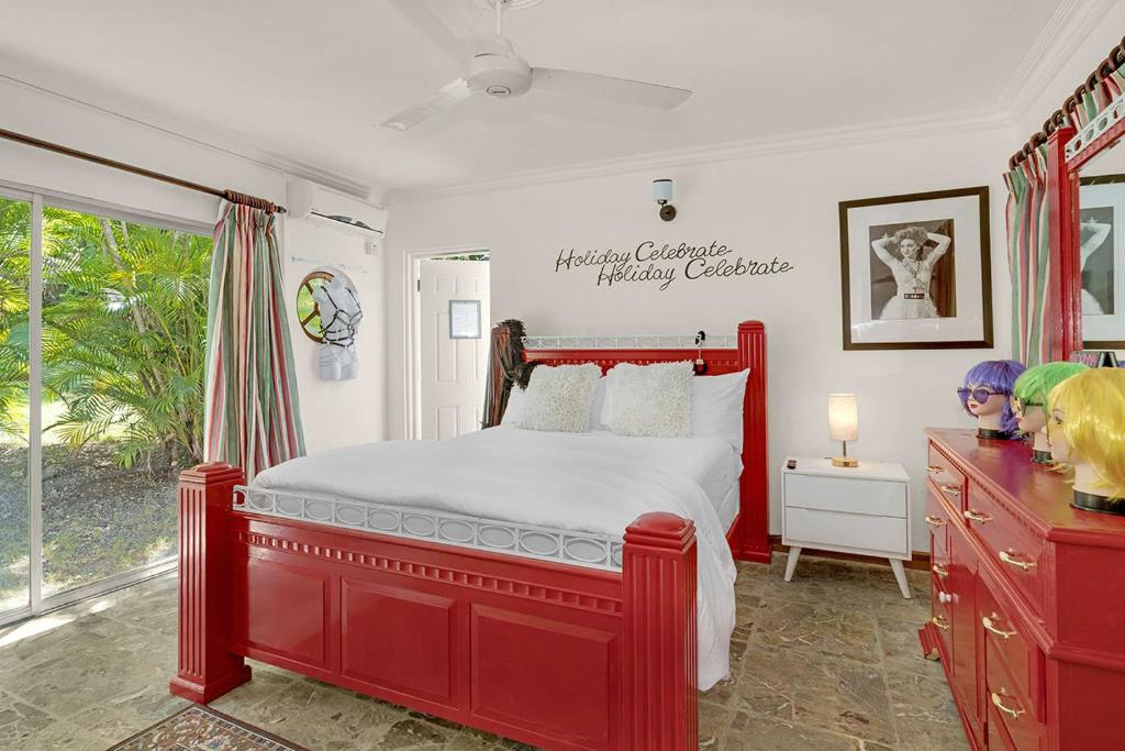 蒙特哥贝Hospitality Expert Madonna Tour Pool Bar Beach的一间卧室设有红色的床和窗户。