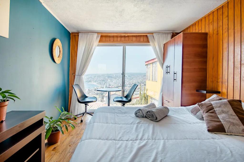 瓦尔帕莱索Casa Altavista的一间卧室设有一张床和一个大窗户