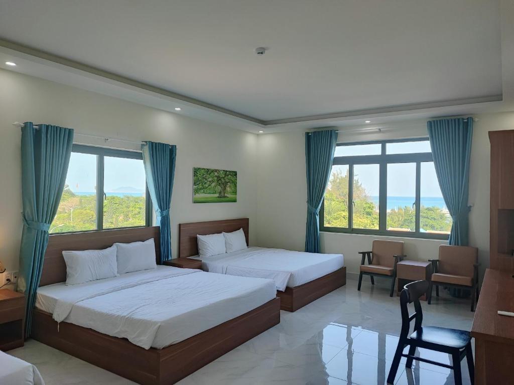 昆岛Hoàng Anh Côn Đảo Hotel的一间卧室配有两张床和一张桌子及椅子