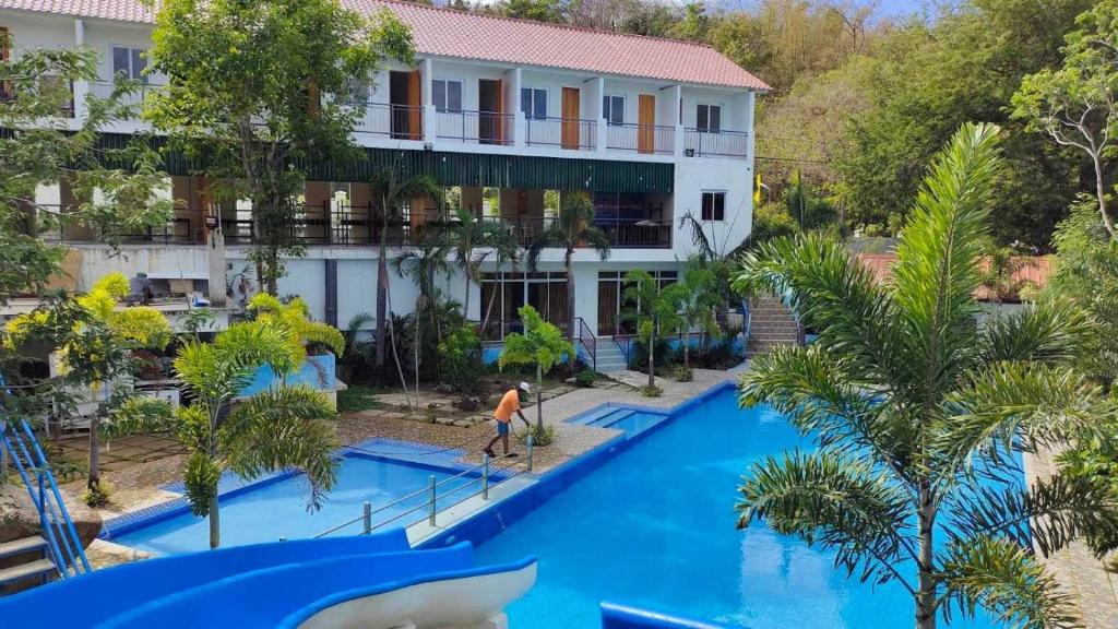 纳苏格布AS Ilaya Resort and Event Place powered by Cocotel的享有度假村游泳池的空中景致,滑梯上有一个男子