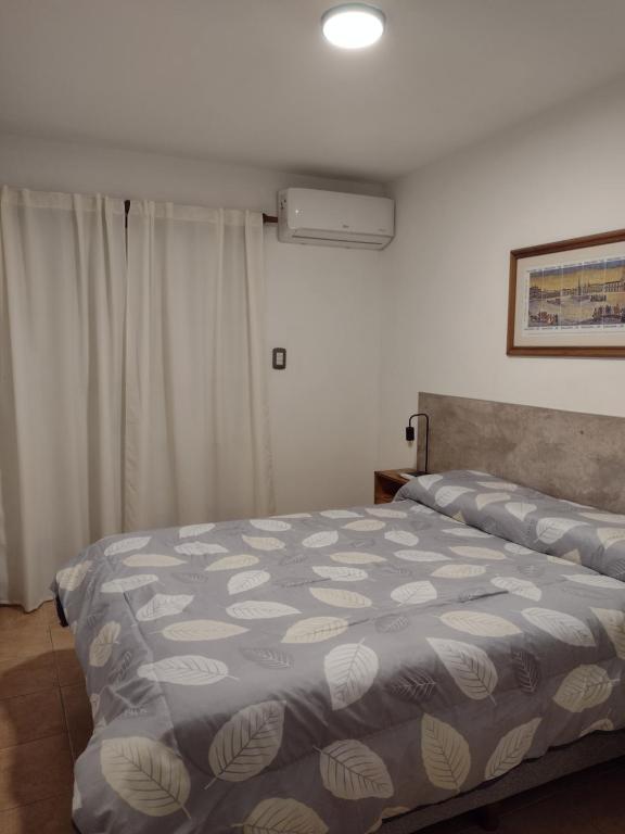 里奥夸尔托Departamento amoblado Rio Cuarto的一间卧室配有一张带蓝白色毯子的床