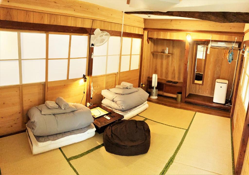 濑户内町奄美ゲストハウス HUB a nice INN的一间设有两张床和一张桌子的房间