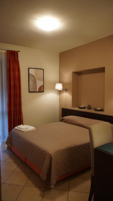 博尔戈马内罗HOTEL DEL CORSO的酒店客房,配有床和镜子