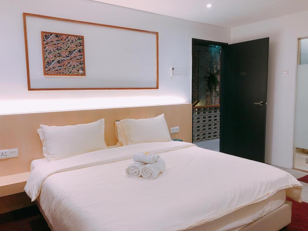 马六甲Domo Japanese Style Bedroom的一间卧室配有一张床,上面有两条毛巾