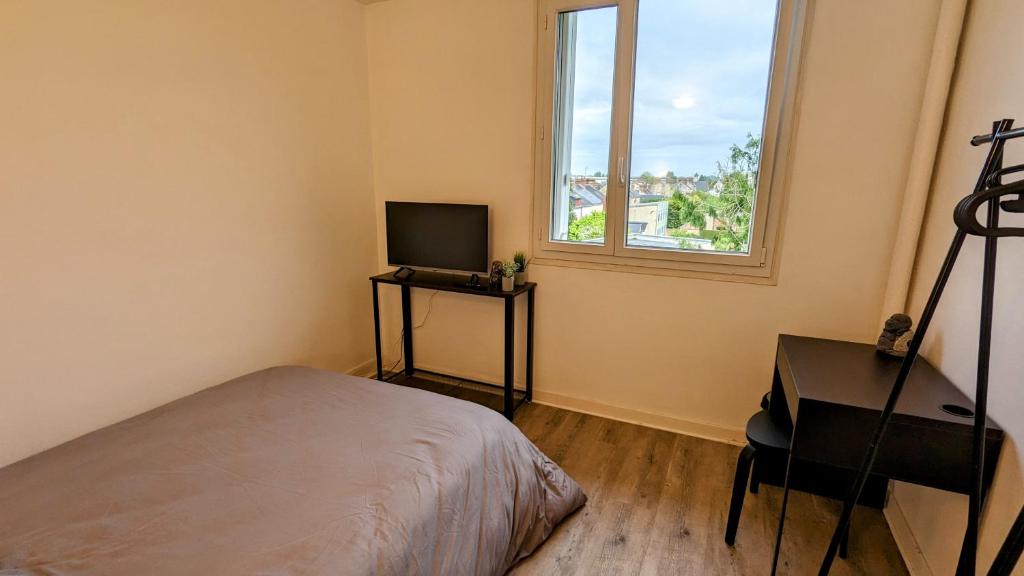 阿朗松Chambre Chez l'habitant - Chez Fab的一间卧室配有一张床、一台电视和一个窗口