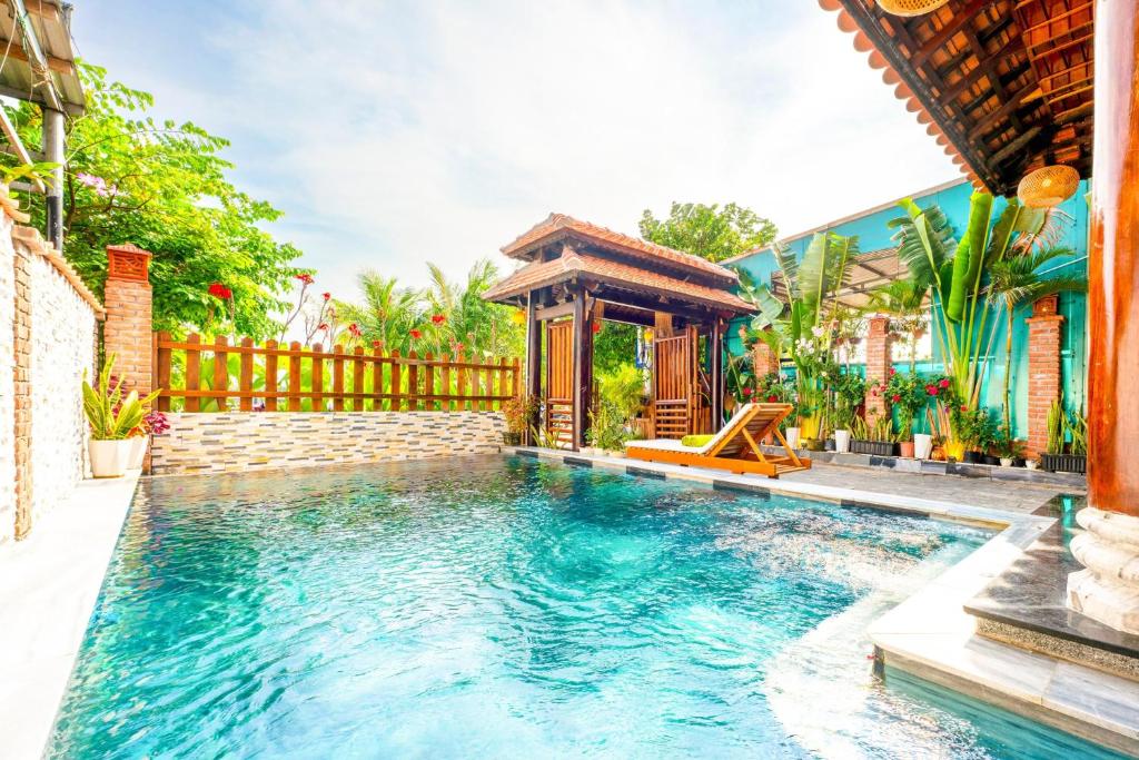 会安Eco Wooden villa Hoi An的房屋旁带凉亭的游泳池