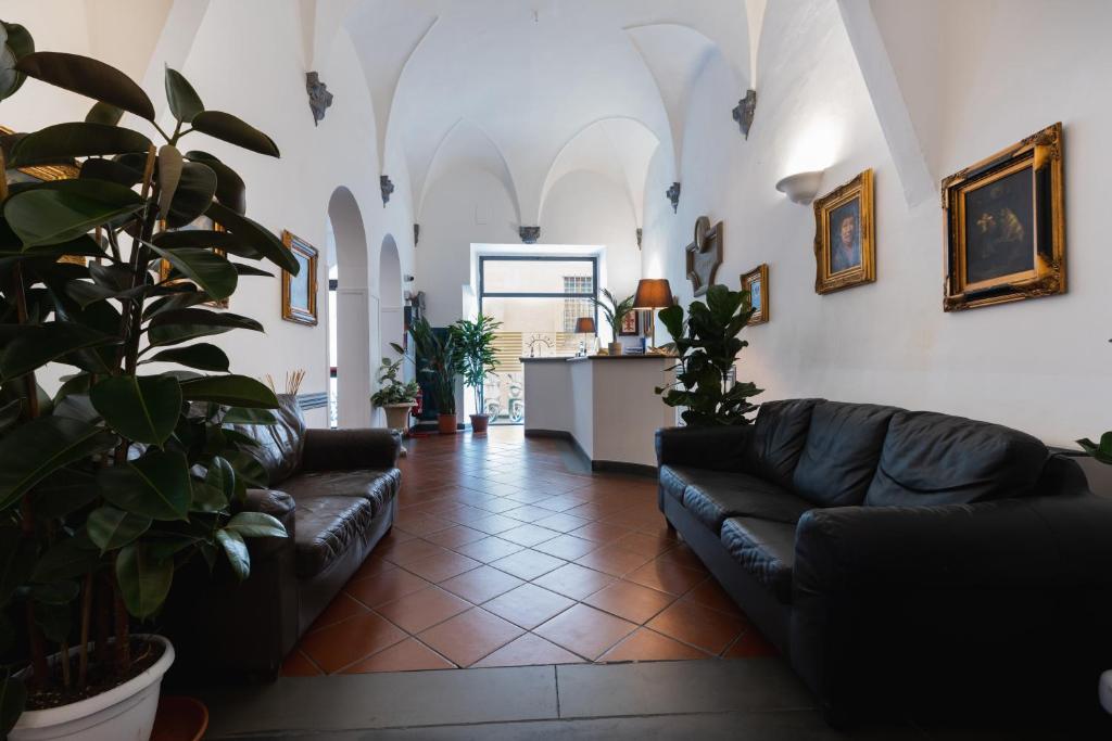 佛罗伦萨尤尼科莫酒店的客厅配有黑色皮革沙发和植物