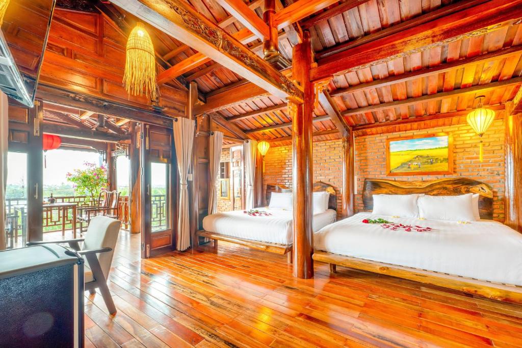 会安Eco Wooden villa Hoi An的配有木天花板的客房设有两张床。