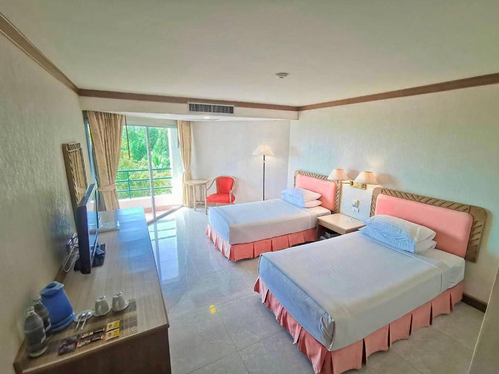 卡农卡农金色海滩酒店的酒店客房设有两张床和电视。