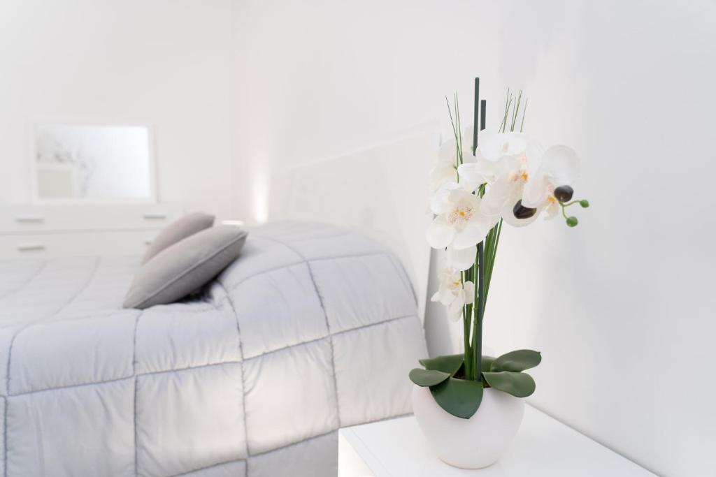 曼弗雷多尼亚Apartment - White Place - Affitti Brevi Italia的白色的客厅,配有白色的沙发和花瓶