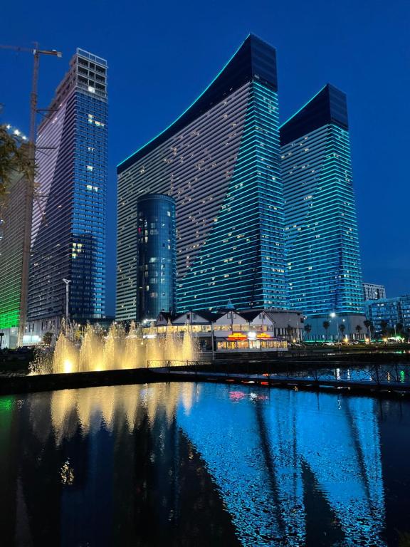 巴统Apartments Black Sea Resort Luxe的一群高大的建筑在晚上在城市里