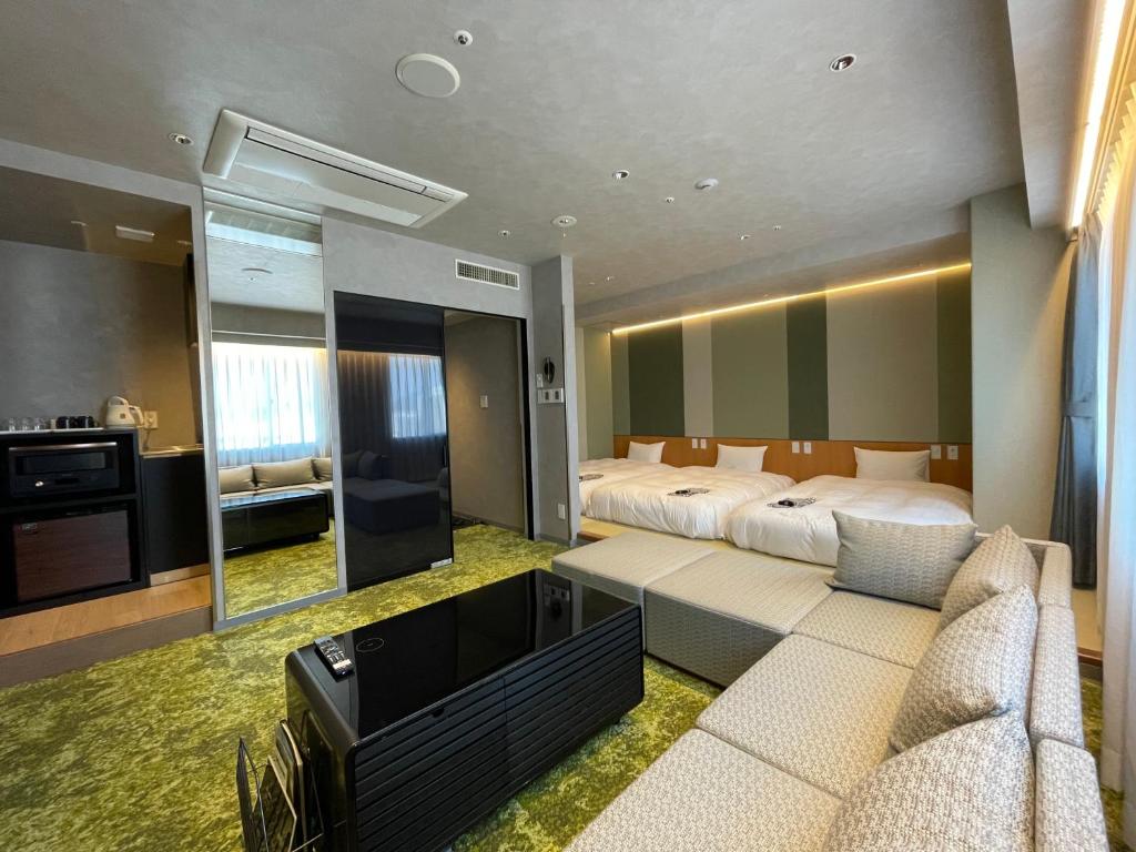 松江市新松江城市酒店的一间卧室配有一张床、一张沙发和一台电视。