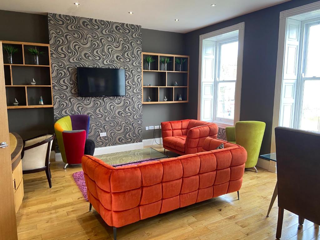 卡斯尔敦Halvard Apartments at Castletown的客厅配有红色的沙发和椅子