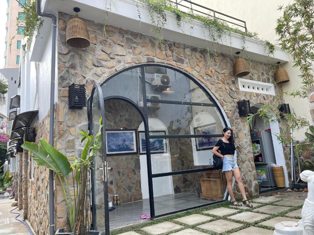 岘港Yên Homestay Đà Nẵng的站在建筑物前面的女人