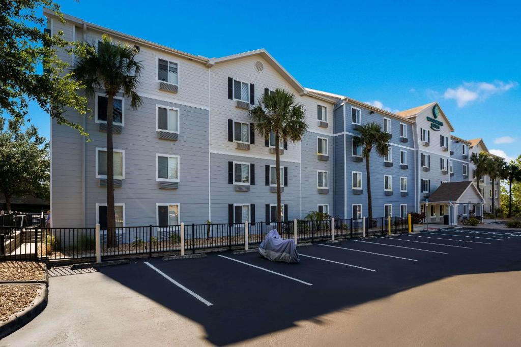 克莱蒙WoodSpring Suites Orlando West - Clermont的一座大型公寓楼,设有棕榈树停车场