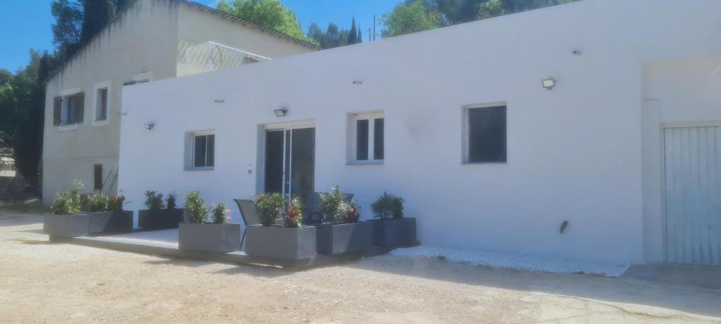 马赛Bas de villa au calme的前面有盆栽植物的白色房子